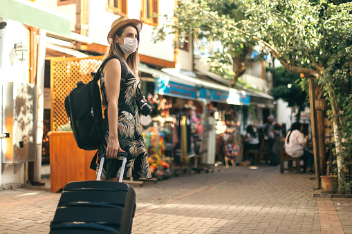Tourist woman wearing protective face mask and  exploring new place